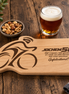 Gepersonaliseerde wielrenner borrelplank van massief beukenhout met gravure, bierglas en borrelnoten.