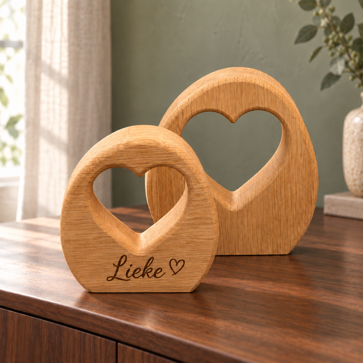 Twee eiken hartbogen van DecoSpace op een houten dressoir, waarvan de voorste is gegraveerd met de naam Lieke en een klein hartje.