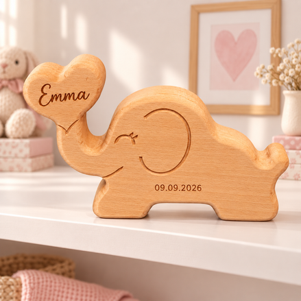 Houten olifant van massief beukenhout met Emma gegraveerd in het hartje en geboortedatum 09.09.2026 op de buik, op een wit plankje in een meisjesbabykamer – DecoSpace.