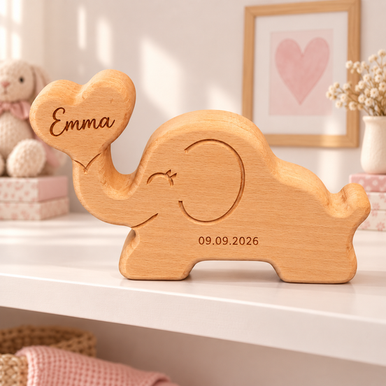 Houten olifant van massief beukenhout met Emma gegraveerd in het hartje en geboortedatum 09.09.2026 op de buik, op een wit plankje in een meisjesbabykamer – DecoSpace.