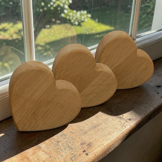 Set van drie massief eikenharten van 15 cm breed en 40 mm dik, handgemaakt door Decospace. De harten staan licht schuin op de zijkant en tonen de natuurlijke houtnerf en ambachtelijke afwerking.